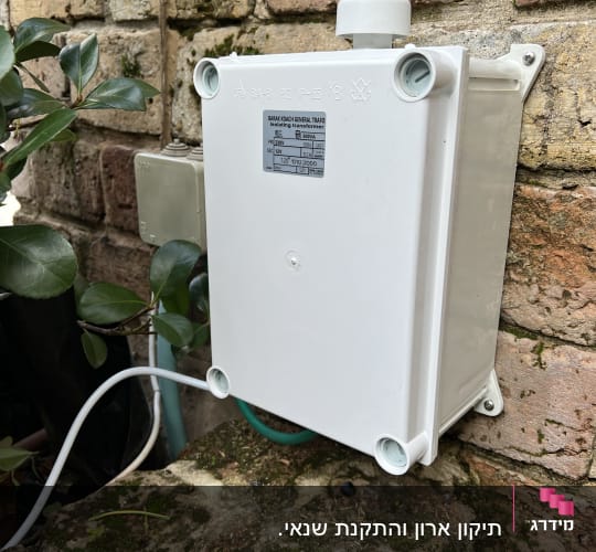 תיבת חשמל לבנה מותקנת על קיר לבנים